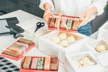Process of packing cookies into a cardboard kraft box, close up,